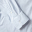 The sleeve of the light blue pinpoint oxford dress shirt with mother of pearl buttons.