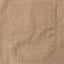 The tan front pocket of the overdyed oxford shirt.