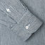 A hickory striped denim work shirt sleeve with two white buttons.