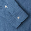 The light denim work shirt sleeve with  two white buttons.