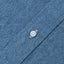 The closeup of the light denim placket with a white button.