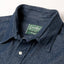 A closeup of the collar with white buttons and a green gitman vintage tag.