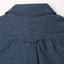 The back of the dark denim work shirt with a locker loop and the back of the collar.