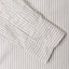 A grey striped shirt sleeve and cuff, two white buttons.