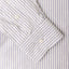 A navy striped shirt sleeve and cuff, two white buttons.