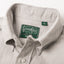 A close up photo of the grey button down collar, white buttons green Gitman Vintage tag.
