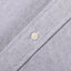 A navy brushed oxford fabric placket, with a white button.