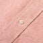 A red brushed oxford fabric placket, with a white button.