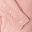 A red shirt sleeve and cuff, two white buttons.