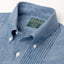 A close up photo of the blue button down collar and a ruffled placket, white buttons green Gitman Vintage tag.