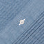 A ruffled blue chambray fabric placket, with a white button.