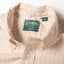 A close-up of the button down collar and a white button on the lined placket.