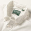 A close-up of the button down collar and a white button on the lined placket.