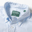 A close-up of the button down collar and a white button on the lined placket.