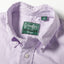 A close-up of the button down collar and a white button on the lined placket.