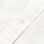 A white button on the stitched placket.