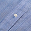 A white button on the stitched placket on the Blue Chambray Dobby Stripe shirt.