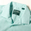 A close-up of the camp collar on the Teal Dobby Stripe Chambray Camp Shirt.