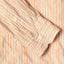 The barrel cuffs on the sleeve of the Tan Awning Stripe shirt with white buttons.