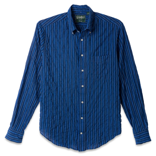 The Indigo Awning Stripe shirt, a stitched placket with barrel cuffs and a front pocket with white buttons.