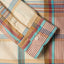 The barrel cuffs on the sleeve of the Tan Archive Madras with white buttons.