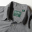 A close-up of the button free collar and a white button on the lined placket.