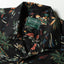 A closeup of the Black Hawaiian Print Camp Shirt collar and the top button loop.