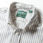 A close-up of the button down collar and a white button on the lined placket