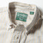 A close-up of the button down collar and a white button on the lined popover placket.