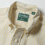 A close-up of the button down collar and a white button on the lined popover placket.