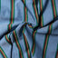 Close-up of the Nicholas Daley Rebel Riot Chambray sport shirt's custom-printed cotton fabric, showcasing its textured chambray weave and Rastafarian stripe.