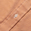 Close-up of the Orange Brushed Chambray sport shirt's button placket featuring classic buttons and soft brushed chambray fabric.