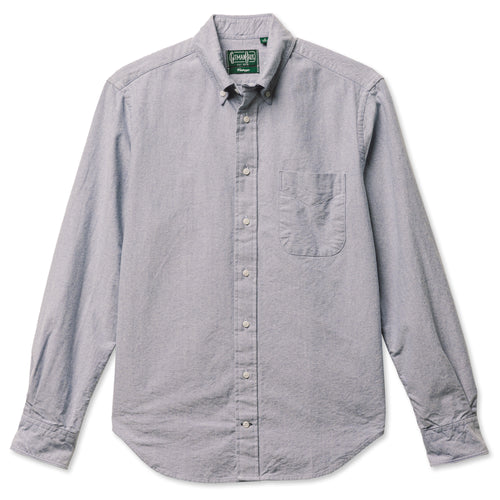 A navy button down shirt with a chest pocket, made from a brushed oxford fabric with white buttons.