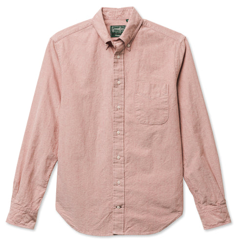 A red button down shirt with a chest pocket, made from a brushed oxford fabric with white buttons.