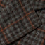 A closeup of the grey checkered tweed simple jacket fabric on the lapel.