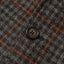 The button on the grey checkered tweed simple jacket.
