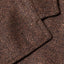 A close-up of the button hole on the lapel of the Brown Donegal bouclé Simple Jacket.