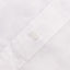 The button on the stitched placket on the White Linen shirt.