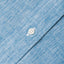 The button on the stitched placket on the Chambray Linen shirt.