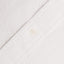 The button on the stitched placket on the White Seersucker shirt.
