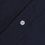 The button on the stitched placket on the Navy Overdye Seersucker shirt.