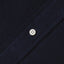 The button on the stitched placket on the Navy Overdye Seersucker Short Sleeve shirt.
