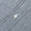A white button with a hickory striped denim placket.