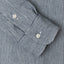 A hickory striped denim sleeve with two white buttons.