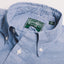 A close up photo of the classic chambray button down collar, white buttons green Gitman Vintage tag.