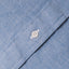 A blue chambray fabric placket, with a white button.
