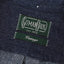 The green gitman vintage tag on the dark denim fabric.