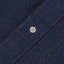The dark denim placket with a white button.