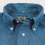 A closeup of the button down collar with white buttons and a green gitman vintage tag.
