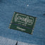 The green Gitman vintage tag on the light denim fabric.